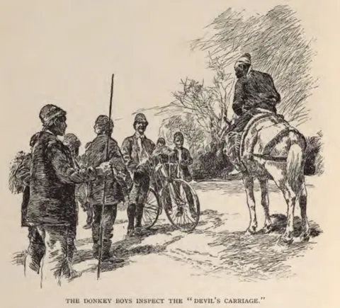 THE DONKEY BOYS INSPECT THE \"DEVIL'S CARRIAGE.\"